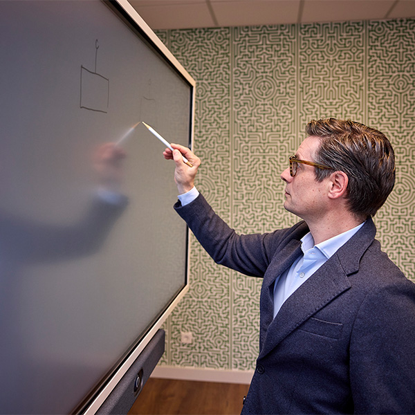 man schrijft op bord